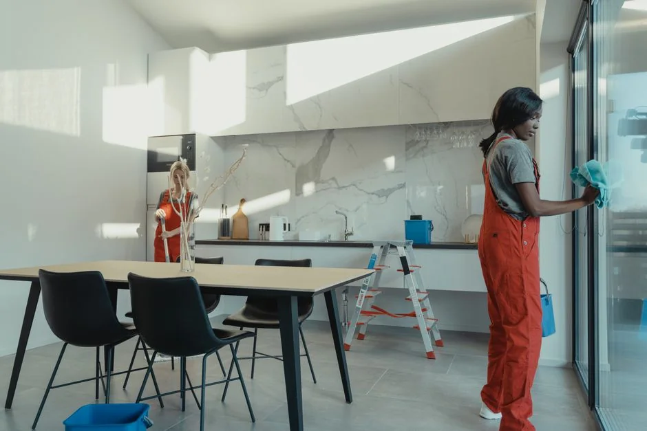 services-02 A woman in a protective suit disinfects an indoor space with fogging equipment.